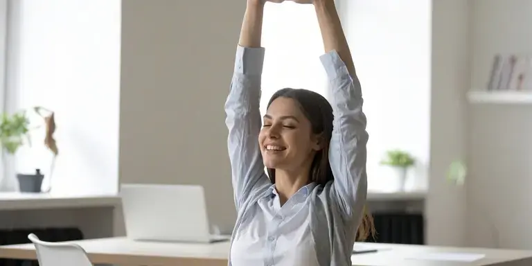 Person macht Mobilitätsübungen im Büro neben einem Schreibtisch