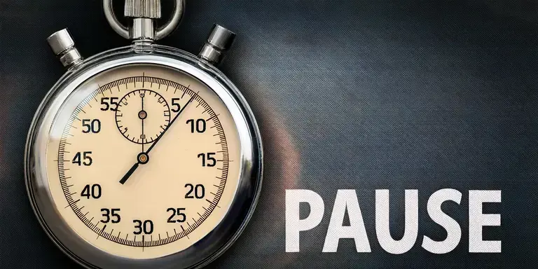 Eine Stoppuhr und das Wort "Pause"