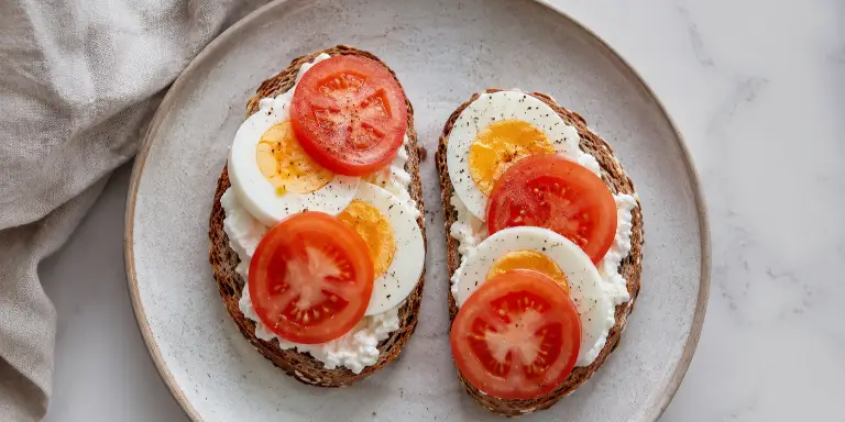 Vollkornbrot mit Hüttenkäse, gekochtem Ei und Tomate
