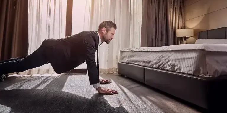 Ein Business-Reisender macht im Hotelzimmer Pushups