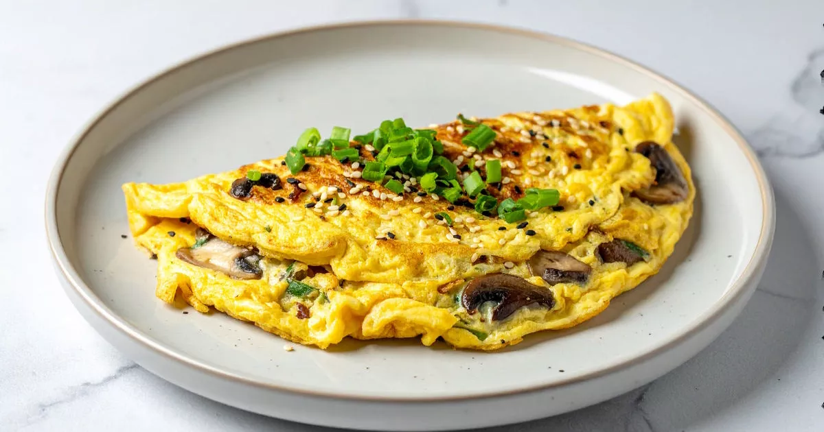 Omelette mit Shiitake und Hüttenkäse, asiatisch gewürzt, mit Frühlingszwiebeln und Sesam serviert