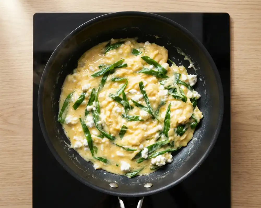 Cremiges Rührei mit Bärlauch und Hüttenkäse in der Pfanne