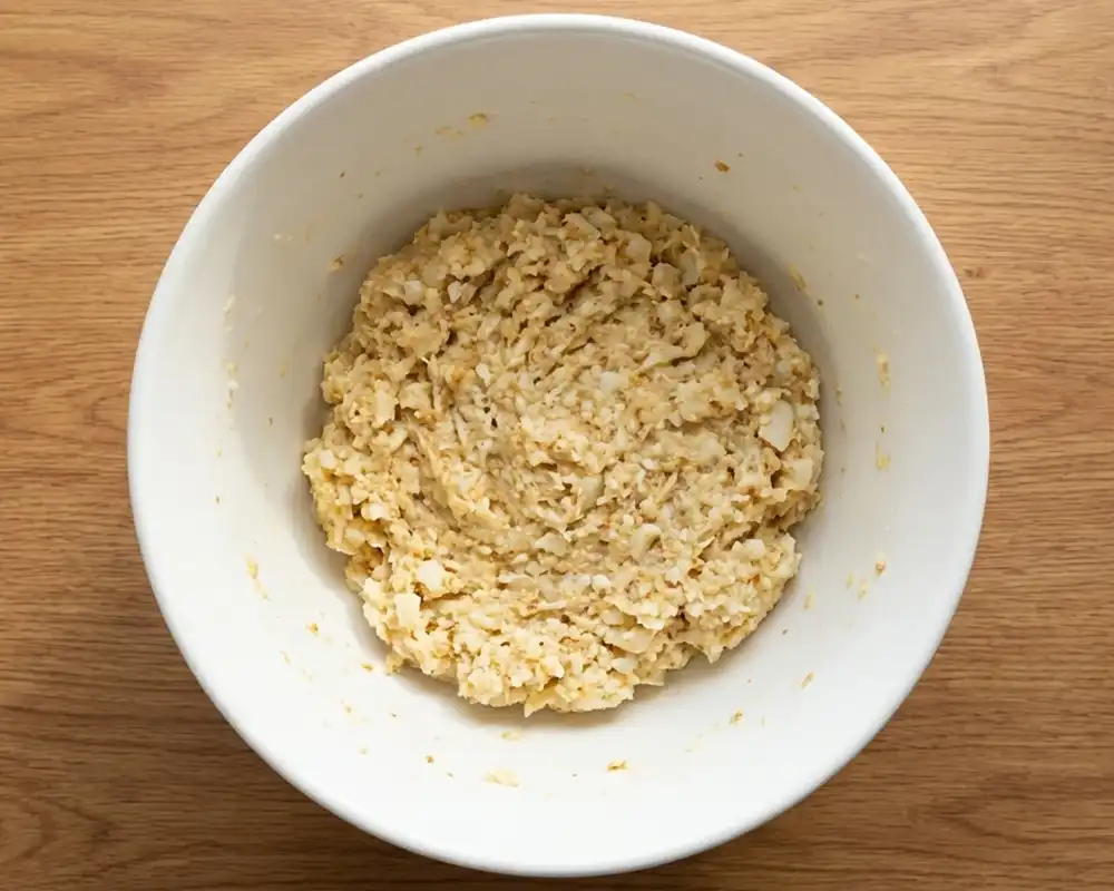Blumenkohl-Parmesan-Masse in weißer Rührschüssel von oben
