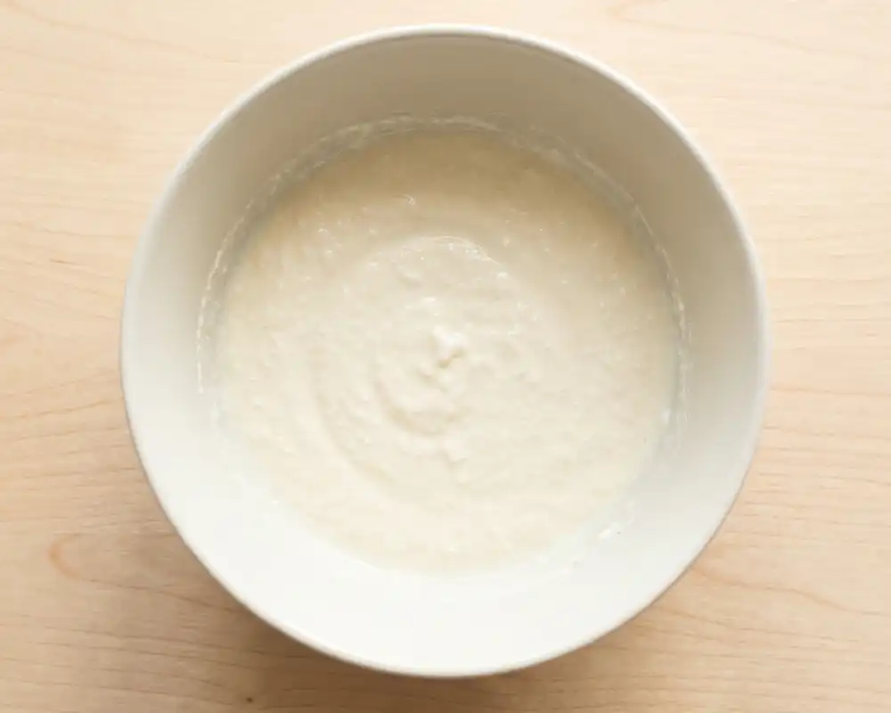 Cremige Joghurt-Frischkäse-Basis für leichten Eiersalat in Schüssel