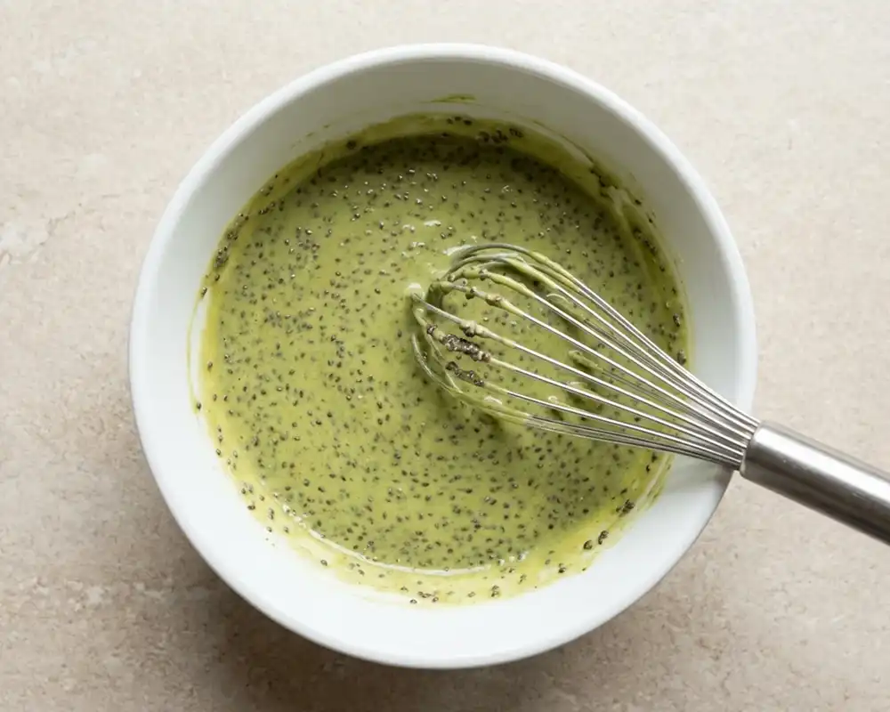 Chiasamen werden in die Matcha-Proteincreme eingerührt – Basis für Matcha Chia Pudding