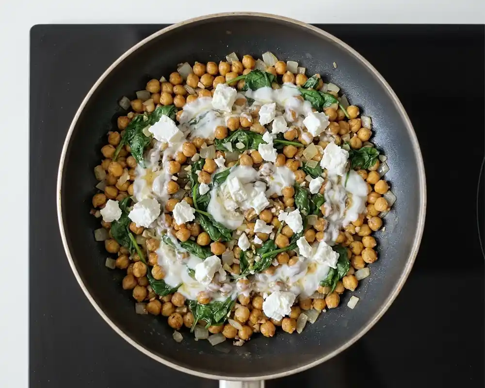 Fertige Kichererbsen-Pfanne mit Skyr, Spinat und Light Feta direkt in der Pfanne von oben fotografiert, cremig und knusprig zugleich