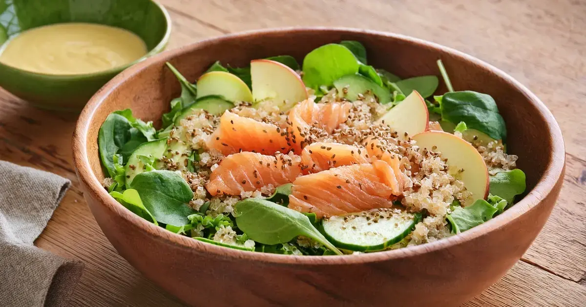 Quinoa-Salat mit Räucherlachs, Apfelspalten, Gurke und Feldsalat