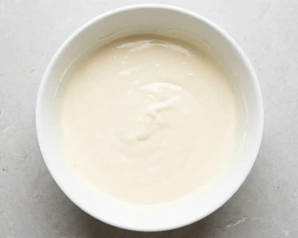 Cremige Quark-Skyr-Käsekuchenmasse in weißer Schüssel von oben fotografiert