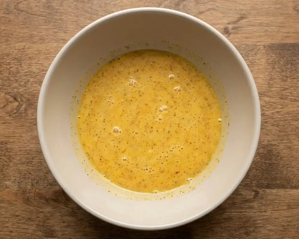 Gewürzte Eier-Skyr-Mischung mit Kurkuma und Kreuzkümmel in Schüssel von oben