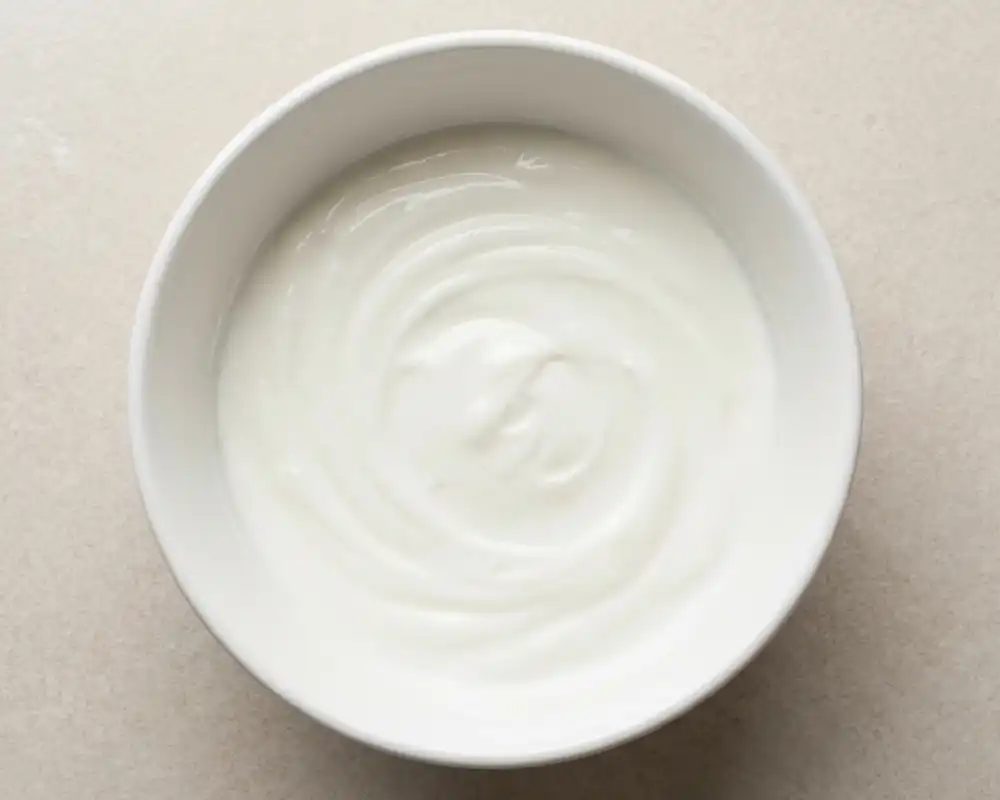 Glatt gerührte Protein-Joghurt-Creme in weißer Schüssel von oben