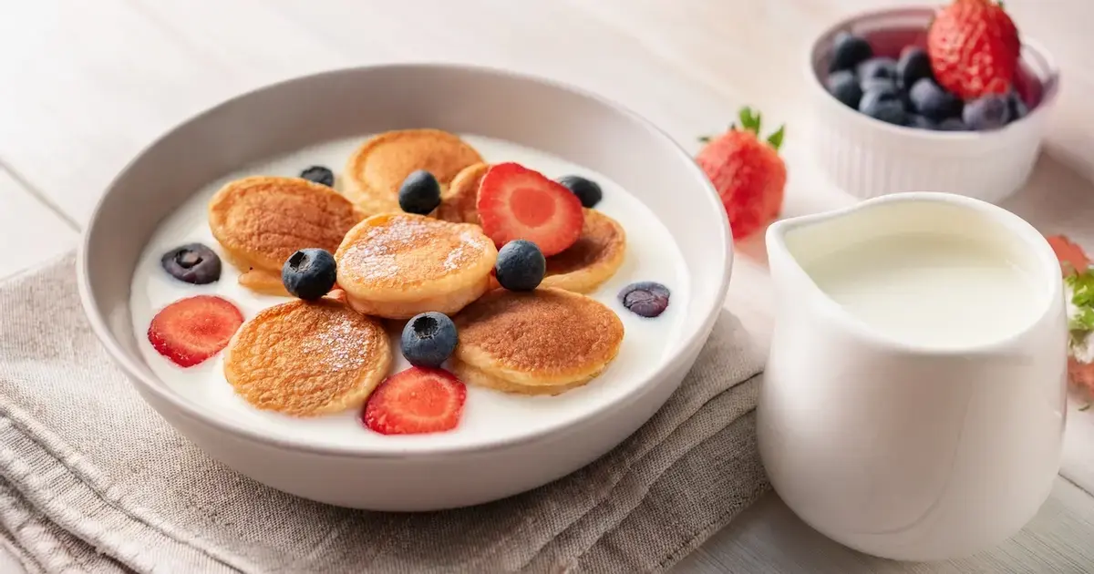 Mini-Protein-Pancakes als Cereal mit Milch und Beeren in einer Schüssel serviert