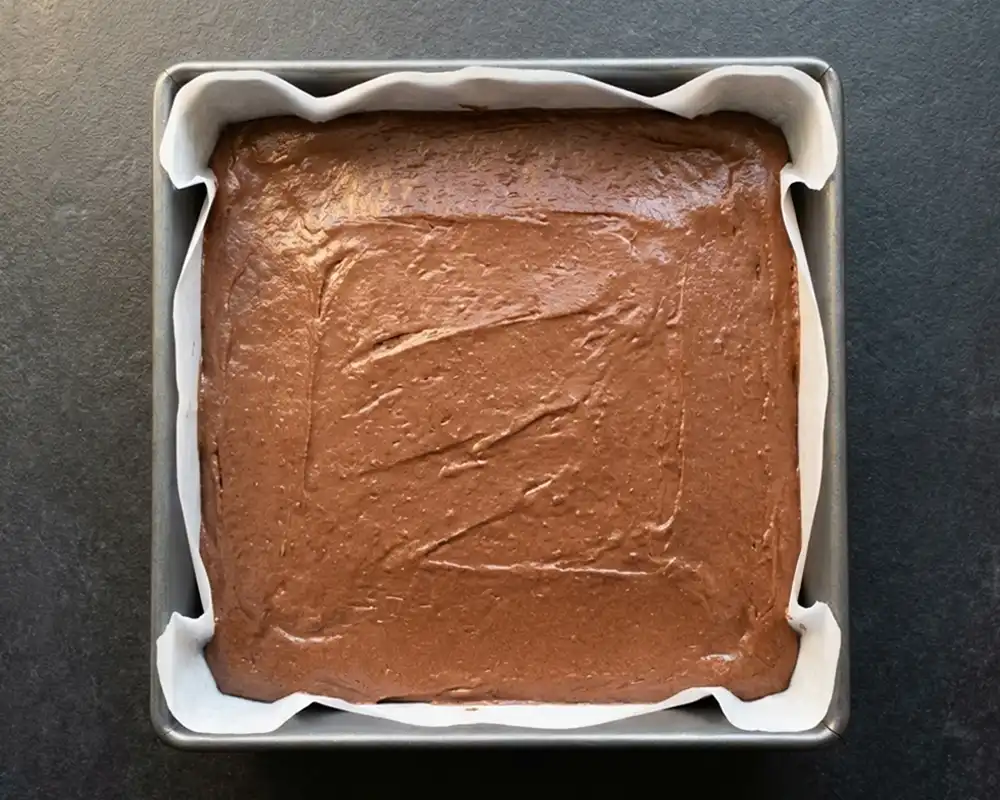 Dickflüssiger Schoko-Protein-Brownie-Teig glattgestrichen in Backform