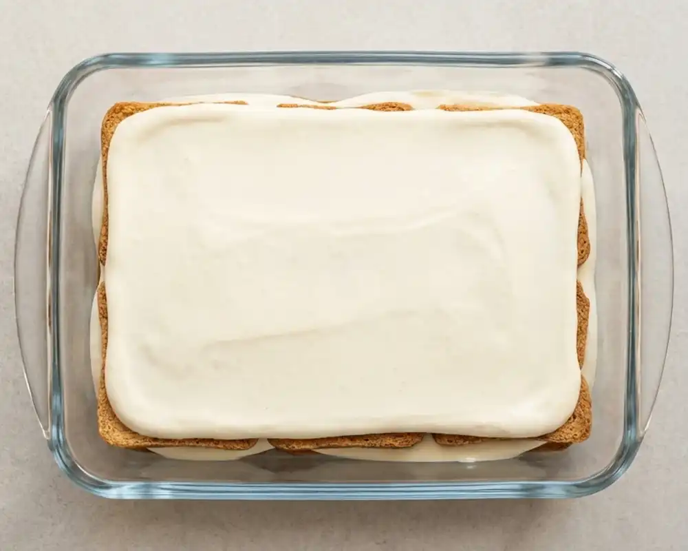 Geschichtetes Protein-Tiramisu mit zwei Zwieback- und Cremeschichten in Glasform