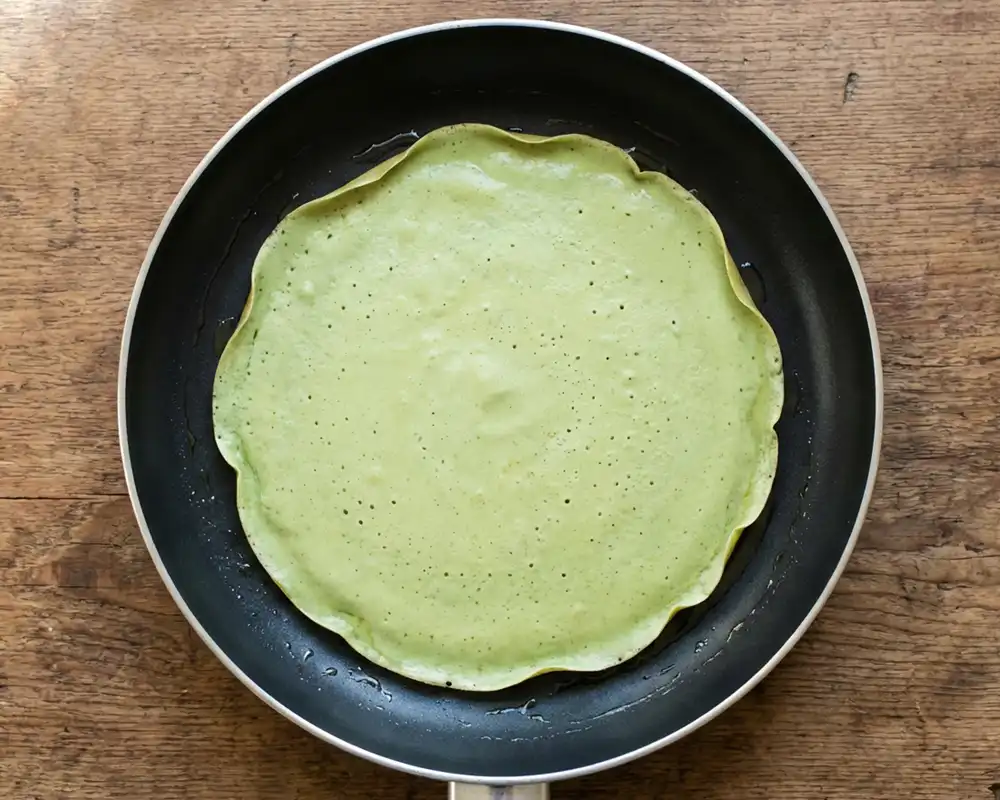 Grüner Protein-Wrap in beschichteter Pfanne von oben beim Ausbacken
