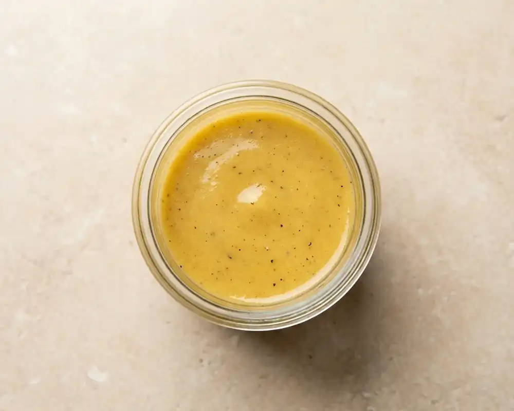 Cremiges Senf-Honig-Dressing im Glas von oben fotografiert