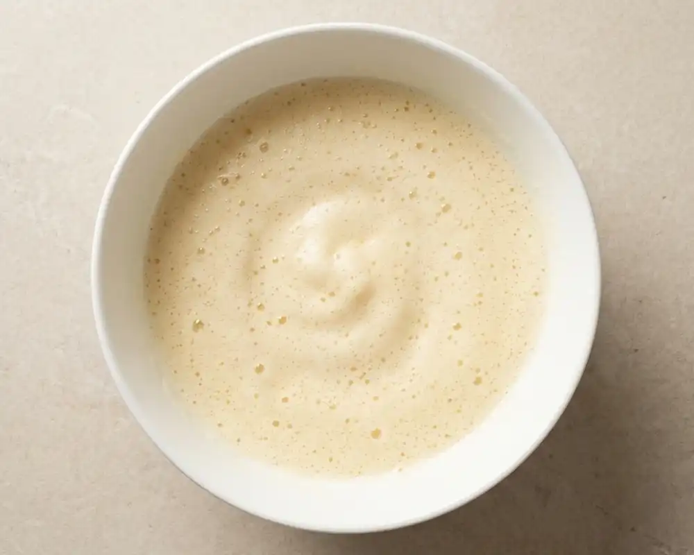 Aufgeschlagene Eier mit Erythrit in weißer Schüssel für Low Carb Zitronenkuchen