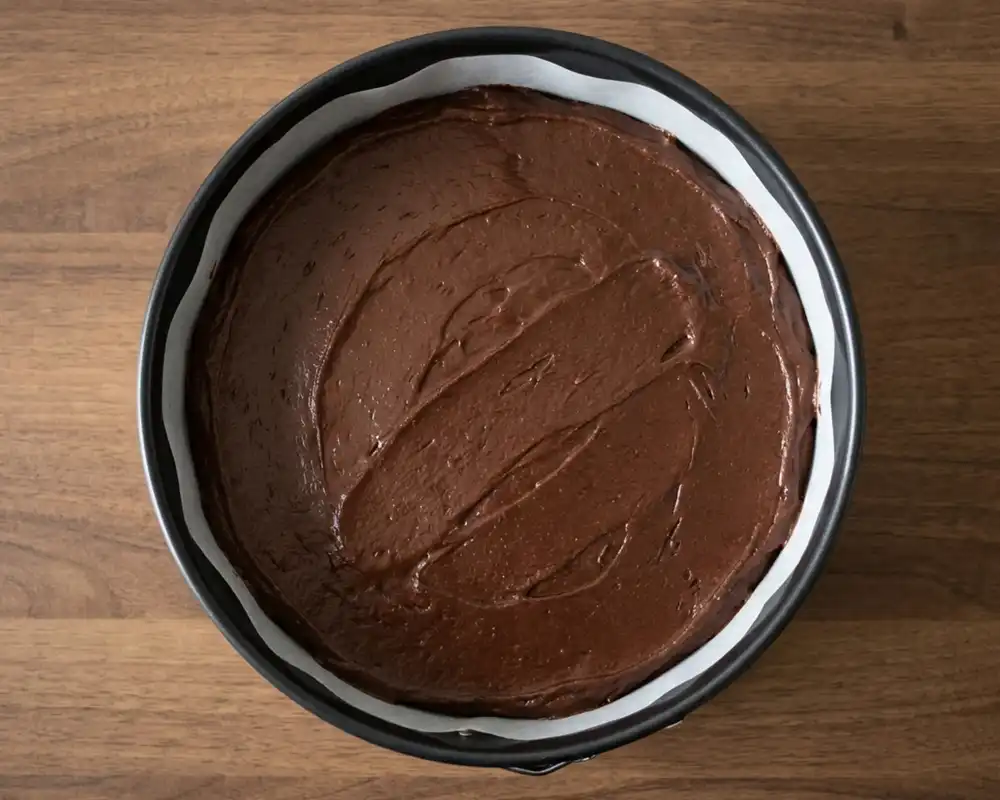 Schokokuchenteig in Springform mit Backpapier von oben vor dem Backen