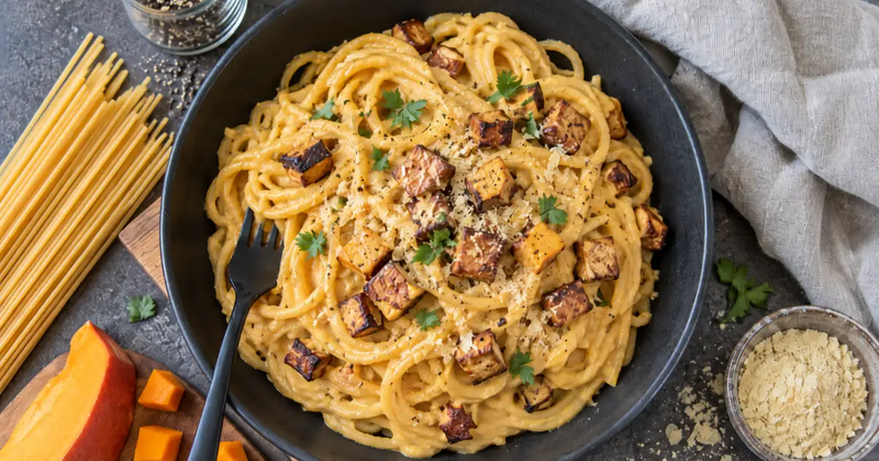 Vegane Kürbis-Carbonara mit cremiger Hokkaido-Sauce, Spaghetti, knusprigem Räuchertofu und Petersilie.