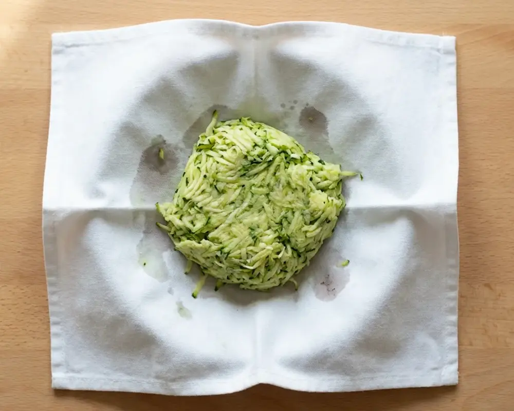 Ausgedrückte geriebene Zucchini im Küchentuch