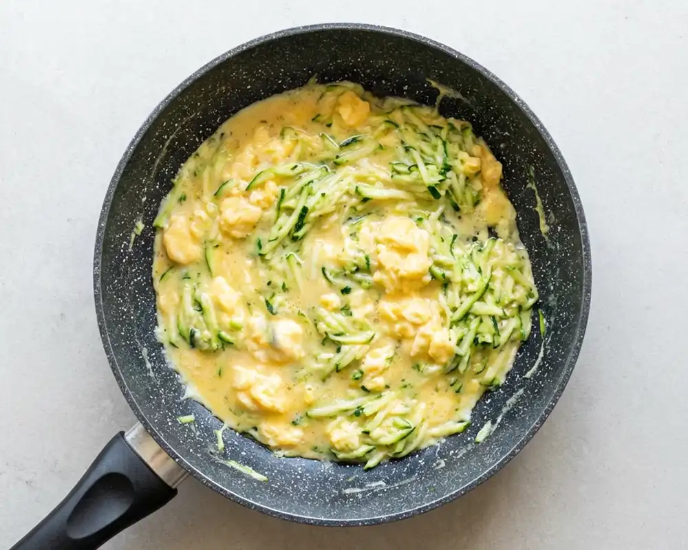 Zucchini und Eier zu Rührei stocken lassen