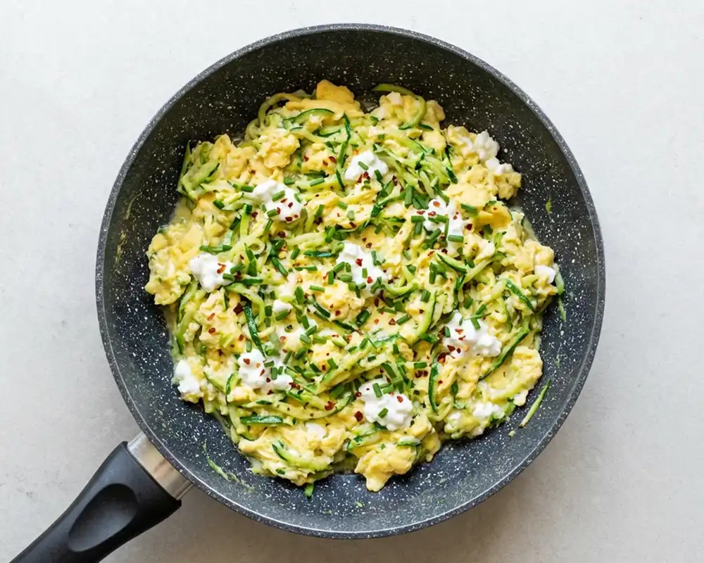 Zucchini Rührei mit Hüttenkäse und Schnittlauch fertig serviert